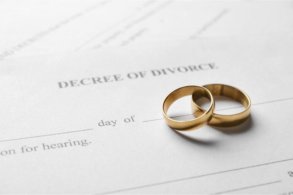 Two wedding rings on a divorce decree document, symbolizing the concept of divorce and legal separation.