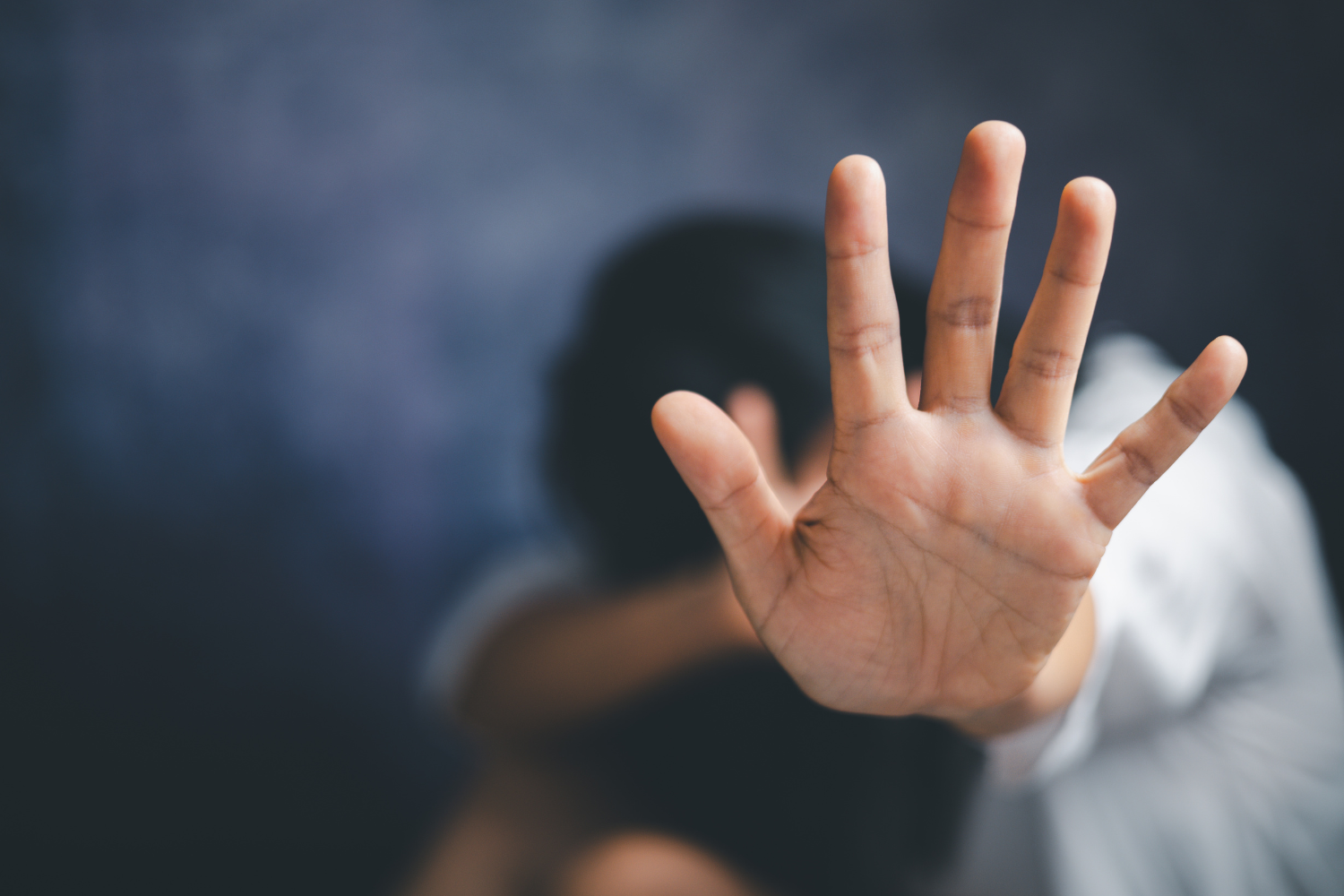 Close-up of a hand raised in defense, symbolizing domestic violence protection and support.