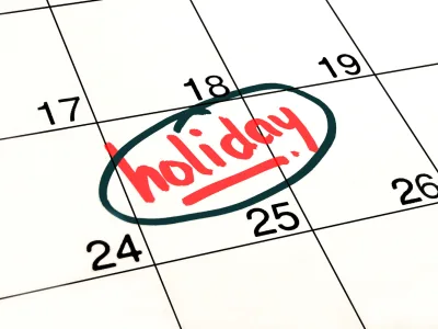 Close-up of a calendar with "holiday" written and circled in red ink.