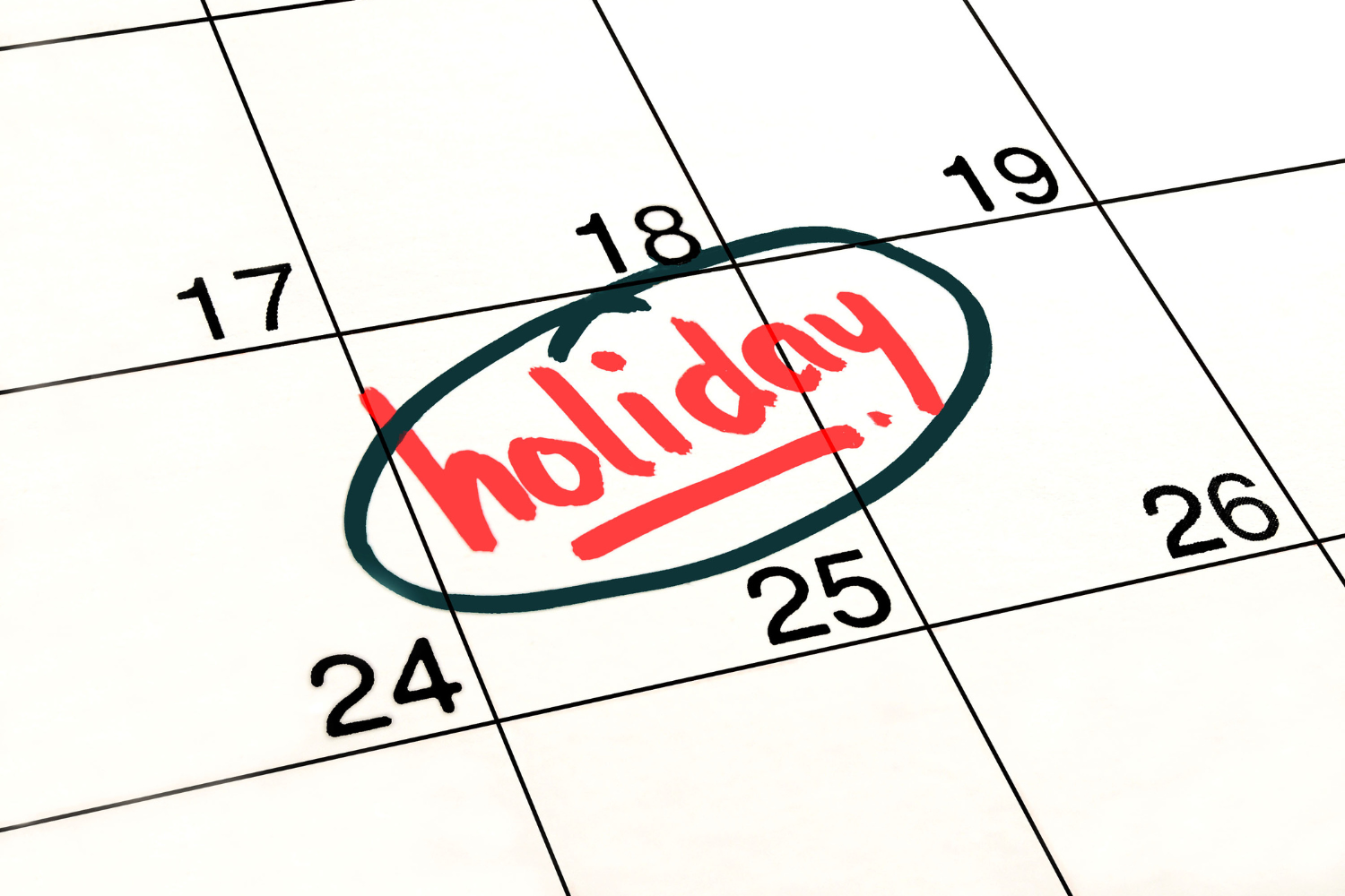 Close-up of a calendar with "holiday" written and circled in red ink.